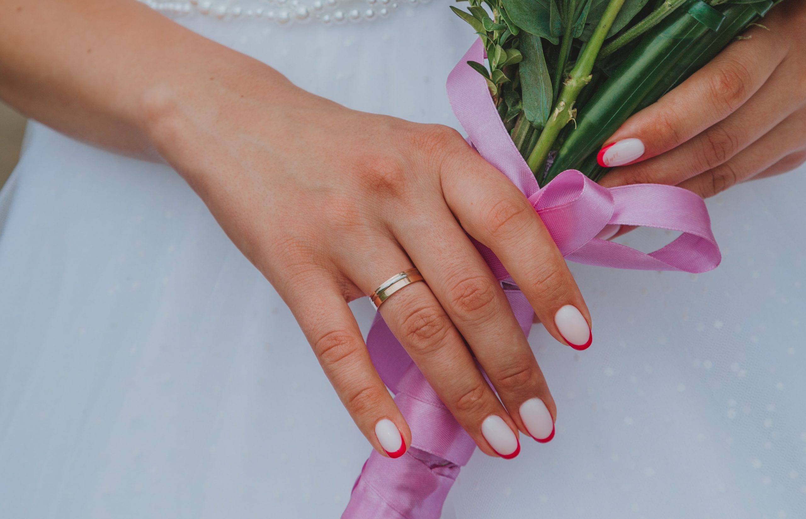 motifs rouges sur des ongles en gel avec un bouquet dans la main
