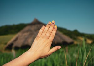 gros plan de maine munie d'ongles en résine devant un paysage flouté