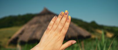 gros plan de maine munie d'ongles en résine devant un paysage flouté