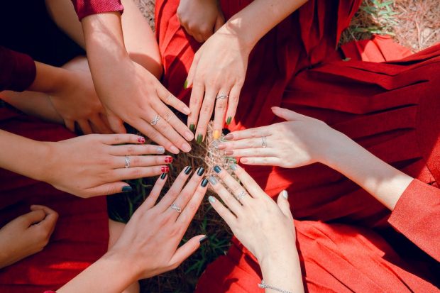 Six mains de femmes en cercle et avec des couleurs d'ongles différentes