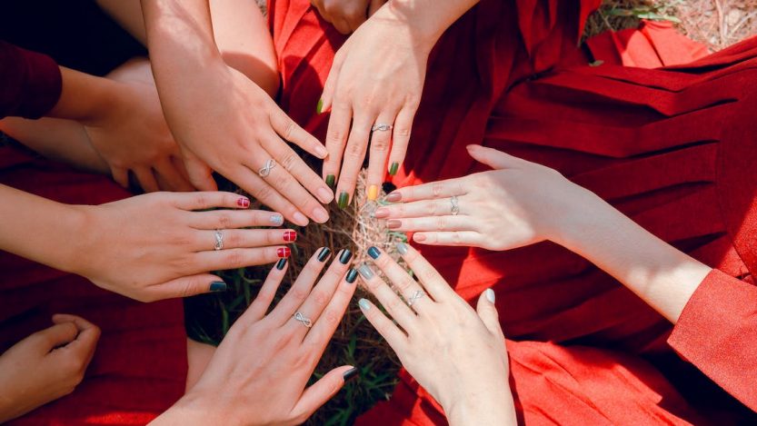 Six mains de femmes en cercle et avec des couleurs d'ongles différentes